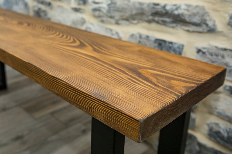 Brown wooden spruce bench with a simple, natural design and sturdy legs, perfect for adding rustic charm to any space