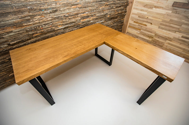 Industrial style corner office desk with a metal frame and wooden top, featuring a minimalist design and spacious work surface.