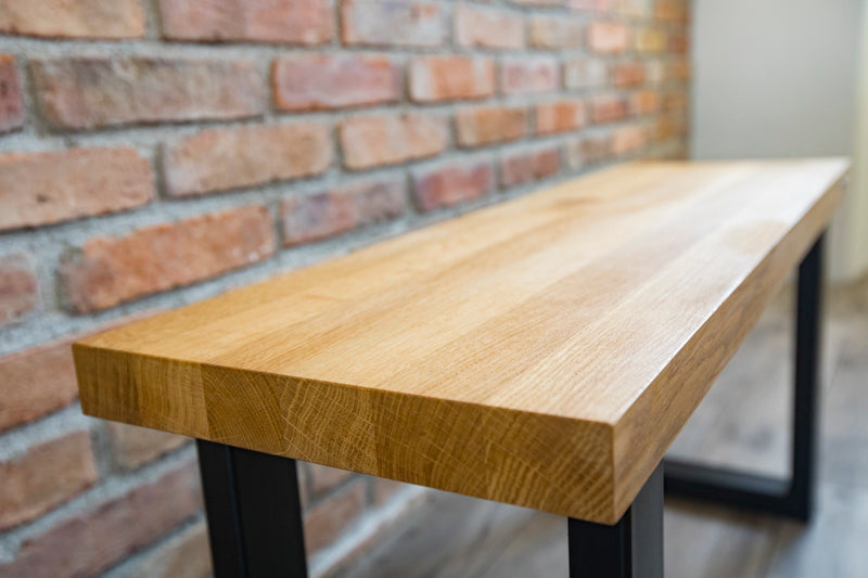 Industrial style oak bench with a rugged wood seat and metal frame, offering a blend of rustic charm and modern design.