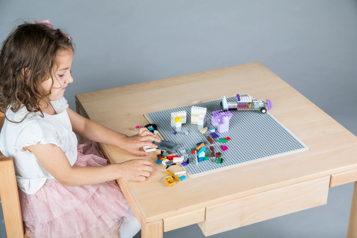 Wooden multifunctional LEGO table with storage drawers and a buildable surface for creative play.