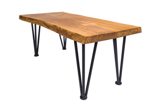 Live edge hairpin oak coffee table with a natural wood finish and sleek metal legs, combining rustic and modern styles.