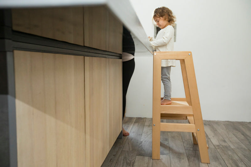 Montessori learning tower with a safe, sturdy design, helping young children reach countertops for independent learning.