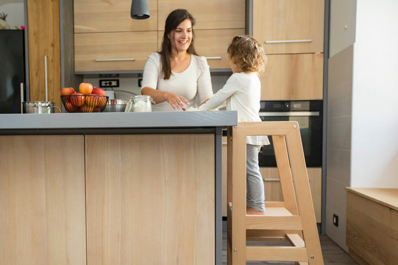Montessori learning tower with a safe, sturdy design, helping young children reach countertops for independent learning.
